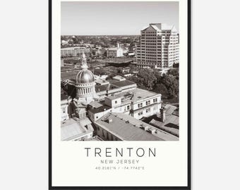 May include: A black and white aerial photograph of Trenton, New Jersey. The photo shows the New Jersey State House, a domed building, and other buildings in the city. The text "TRENTON NEW JERSEY 40.2161°N / -74.7742°E" is at the bottom of the photo.