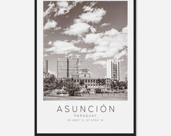 May include: A black and white photograph of the city skyline of Asuncion, Paraguay. The photo shows a cityscape with buildings and a cloudy sky. The text "Asuncion, Paraguay 25.2637° S, 57.5759° W" is at the bottom of the image.