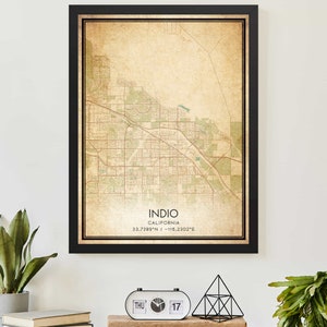 May include: Vintage style map print of Indio, California. The map is printed on aged paper with a brown and green color scheme. The text "Indio, California 33.7389°N / -116.2302°E" is printed at the bottom of the map.
