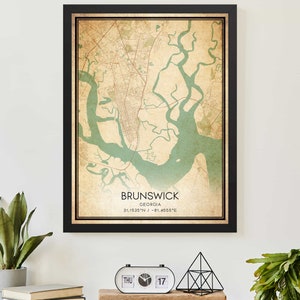 May include: A vintage-style map print of Brunswick, Georgia, with a black frame. The map is in shades of brown, green, and white, with the city's waterways highlighted in green. The text "BRUNSWICK, GEORGIA, 31.1535°N / -81.4665°E" is printed at the bottom of the map.