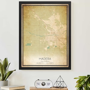 May include: A vintage-style map print of Madera, California, with a black frame. The map is in shades of green and brown, with a faded, antique look. The text "Madera, California" and the coordinates "36.9681°N / -120.1088°E" are printed at the bottom of the map.