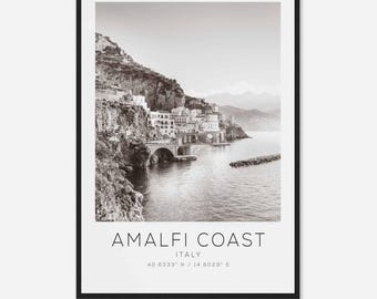 May include: A black and white photograph of the Amalfi Coast in Italy. The image shows a coastal town built into the side of a cliff with a bridge connecting the town to the mainland. The text "Amalfi Coast, Italy, 40.6333° N / 14.6029° E" is printed below the image.