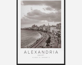 Może przedstawiać: Czarno-białe zdjęcie Aleksandrii w Egipcie. Zdjęcie przedstawia panoramę miasta z budynkami wzdłuż wybrzeża. Tekst "ALEXANDRIA EGYPT 31.2001° N / 29.9187° E" znajduje się na dole obrazu.
