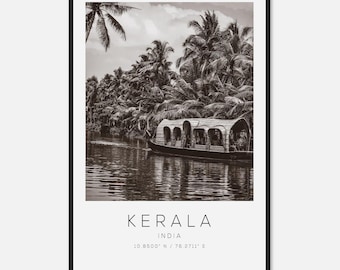 May include: Black and white framed print featuring a Kerala, India landscape. A boat floats on the water, surrounded by palm trees. The print includes the text "Kerala, India" and coordinates 10.8500° N / 76.2711° E.