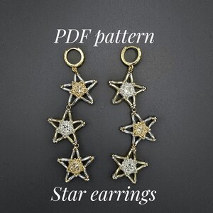Könnte beinhalten: Ein Paar Sternohrringe mit goldfarbenen Reifen und sternförmigen Anhängern. Die Anhänger wechseln sich zwischen gold- und silberfarbenen Sterndesigns ab. Der Text "PDF pattern" und "Star earrings" wird angezeigt.