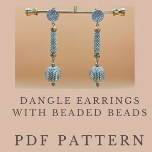 Puede incluir: Un par de pendientes colgantes con cuentas de abalorios. Los pendientes son plateados y dorados con un diseño de abalorios blancos. Los pendientes cuelgan de un soporte dorado. El texto "DANGLE EARRINGS WITH BEADED BEADS PDF PATTERN" está debajo de los pendientes.