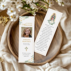 Puede incluir: Dos marcadores conmemorativos con bordes dorados y detalles florales. Uno presenta una foto y el texto: "En Memoria Amorosa, Adriana Martínez, 23 de junio de 1975 - 15 de enero de 2026." El otro tiene una imagen religiosa y texto.