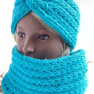 Könnte beinhalten: Ein türkisfarbenes Strickset aus Stirnband und Halstuch. Das Stirnband ist oben auf dem Kopf zu einem Knoten gebunden. Der Halstuch ist im Cowl-Stil. Das Set ist von Handmade by Tonika hergestellt.
