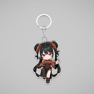 Könnte beinhalten: Schlüsselanhänger mit einem Anime-Charakter im Chibi-Stil. Der Charakter hat schwarzes Haar, rote Augen und trägt ein rot-schwarzes Outfit. Der Schlüsselanhänger hat einen silbernen Metallring.