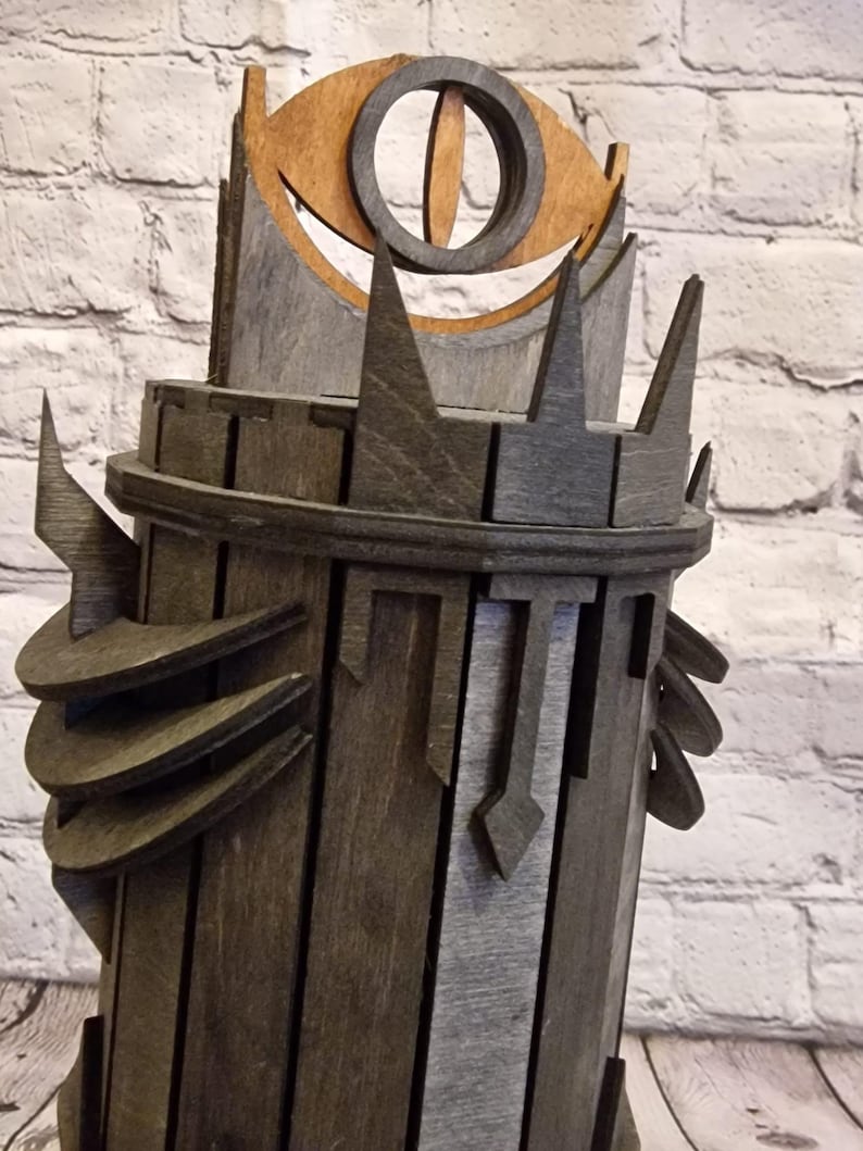 May include: A wooden tower with a dark brown finish and a large eye on top. The eye is made of wood and has a brown and black color scheme.