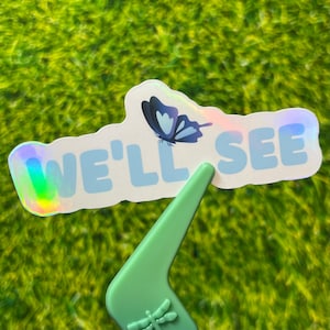 We’ll See vinyl sticker - blue friendly butterfly - water-resistant smooth holographic for water bottles, laptops, phones etc