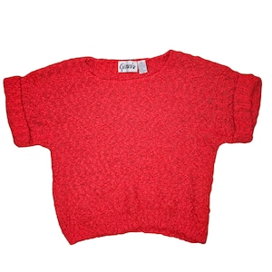 May include: A bright red, short-sleeved sweater with a textured knit pattern. The sleeves are cuffed, and the neckline is crew. The label reads "Genesis". This vintage top is a vibrant addition to any wardrobe.