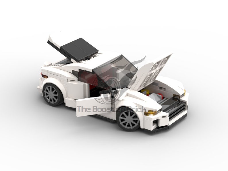 May include: A white toy sports car with the hood and doors open, revealing the engine and interior. The car has gray wheels and black accents. The text "The Boost Brick" is visible on the side of the car.