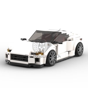 May include: A white sports car model constructed from interlocking toy bricks. The car features a sleek design with dark tinted windows and gray wheels. The front of the car has black detailing and headlights. The logo "The Boost Garage" is visible on the side.