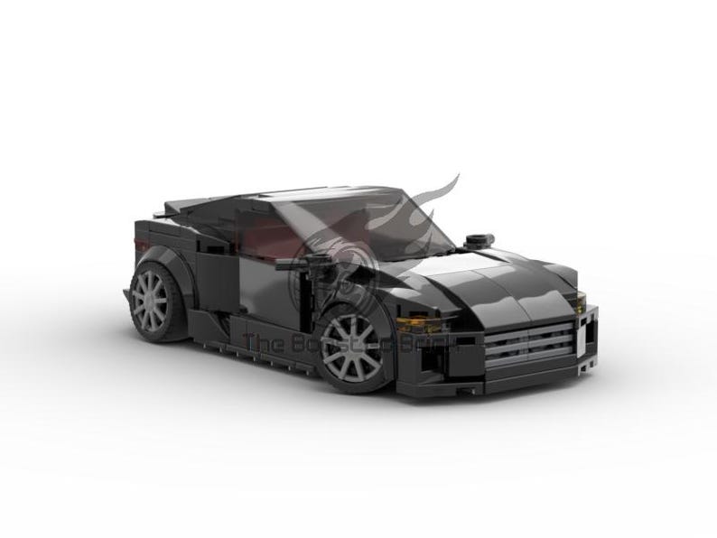 May include: A black sports car model made of interlocking toy bricks. The car has a sleek design with a low profile, detailed wheels, and a tinted windshield. The model is set against a white background.