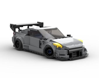 May include: A gray Lego model of a race car with a large rear wing, yellow headlights, and black accents.