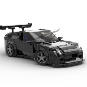 May include: A black Lego model car with a large rear wing and a detailed front end. The car has a black body and black wheels.