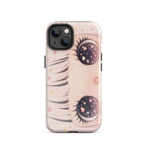 Puede incluir: Funda de teléfono con una ilustración de cara de dibujos animados. Los ojos presentan un diseño de galaxia, y la funda es rosa y blanca con detalles de corazones y estrellas.