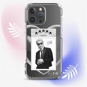 May include: Clear phone case with a black and white image of a person wearing sunglasses and a suit. The image has the text "Stray Kids" and a signature. The case has a clear border.