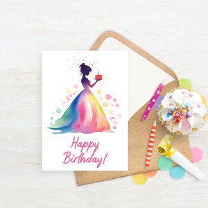 May include: A white card with a watercolor illustration of a woman in a rainbow dress holding a small red cake with a single candle. The text "Happy Birthday!" is written in pink below the illustration.