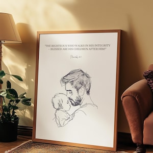 Op de afbeelding: Een ingelijste kunstdruk met een lijntekening van een vader en kind in zwart en wit. De print bevat de tekst "THE RIGHTEOUS WHO WALKS IN HIS INTEGRITY - BLESSED ARE HIS CHILDREN AFTER HIM!" en "Spreuken 20:7". De lijst heeft een warme bruine kleur.