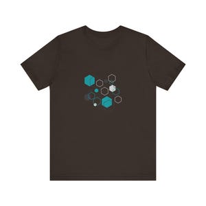 May include: A dark brown t-shirt with a geometric design featuring teal and gray hexagons and cubes.
