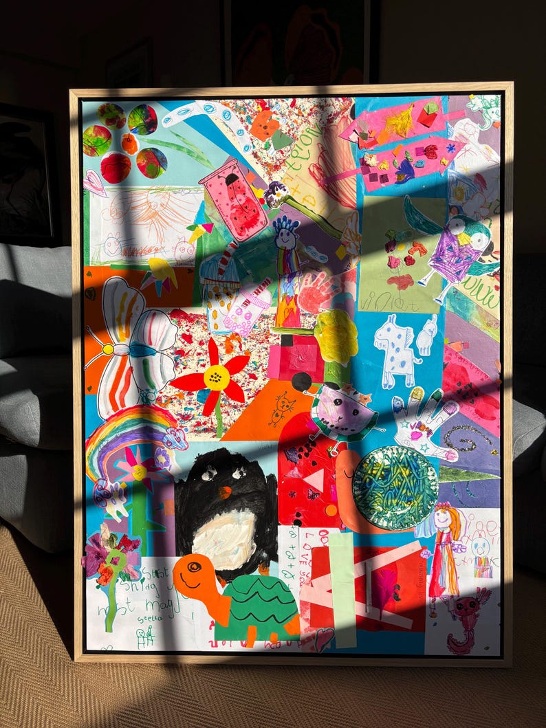 May include: A framed collage of children's artwork featuring a variety of colorful drawings, including a butterfly, a rainbow, a turtle, a black bird, and various abstract shapes and patterns in bright shades of red, blue, orange, and green.