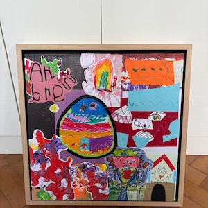 May include: A framed collage artwork featuring a vibrant mix of children's drawings, including a large colorful oval, abstract red shapes, a figure with a hat, and a house. The text "Ah bren" is written in black marker on the left side of the piece.