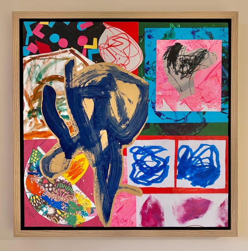 May include: A framed mixed-media collage painting featuring a large, central dark blue and gold brushstroke overlay. The composition includes various colorful sections with abstract shapes, scribbles, geometric patterns, and vibrant pink, red, and blue paint.
