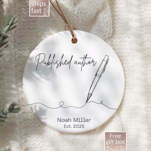May include: White ceramic ornament with the words "Published author" in elegant script, a pen illustration, and the name "Noah Miller Est. 2025". The ornament has a gold string for hanging.