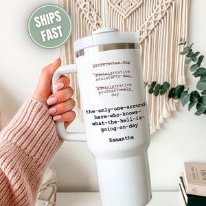 May include: White insulated tumbler with a handle and lid. The tumbler has black text that reads "secretaries day", "administrative assistants day", "administrative professionals day", and "the-only-one-around-here-who-knows-what-the-hell-is-going-on-day". The name "Samantha" is printed below the text.