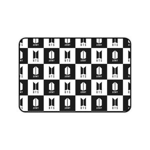 May include: A rectangular black and white patterned mousepad. The design features a checkerboard pattern with the words "BTS" and "ARMY" in white lettering. The mousepad has rounded corners.