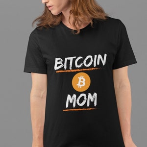 May include: Black t-shirt with white text that reads "Bitcoin B Mom" with a stylised orange Bitcoin symbol.