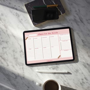 Può includere: Un tablet digitale che mostra un pianificatore settimanale con la scritta "Plans for the Week". Uno stilo bianco, una tazza di caffè, uno smartphone e una penna sono su una superficie di marmo. Il pianificatore ha accenti rosa e sezioni per ogni giorno.