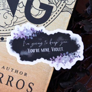 May include: A black and white sticker with purple flowers and the text "I'm going to keep you. You're mine. Violet."
