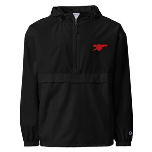 May include: Black Champion windbreaker jacket with a red Arsenal Football Club logo on the left chest.