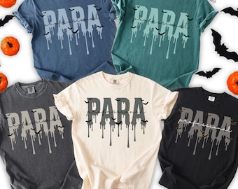 May include: Five short-sleeve crew neck t-shirts in denim, blue spruce, pepper, ivory, and black colors. Each shirt features the text "PARA" in a large, dripping font with the word "professional" in script and small black bat silhouettes.
