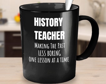 May include: Black coffee mug with white text that reads "History Teacher Making the Past Less Boring One Lesson at a Time".