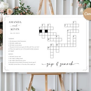 May include: A white framed crossword puzzle on an easel, with the names "AMANDA and KEVIN" and the date "06.20.2025" at the top. The puzzle is titled "sip & search" and includes clues for a wedding game.