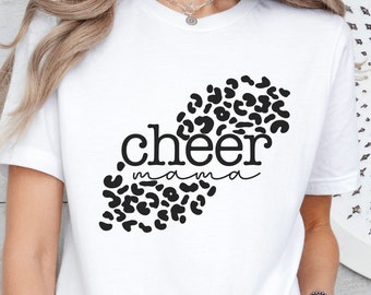 May include: White t-shirt with the words "cheer mama" in black script and a black leopard print design. The shirt is made of a soft material and is suitable for casual wear.