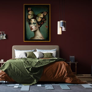 May include: A bedroom interior with a burgundy wall, a bed with green and brown bedding, a framed painting of a woman with butterflies on her head, and a chair with a cream cushion.