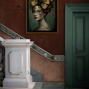 May include: A framed painting of a woman with a butterfly covering her face. The butterfly is green and yellow with brown accents. The woman is wearing a floral crown and has a light blue background.