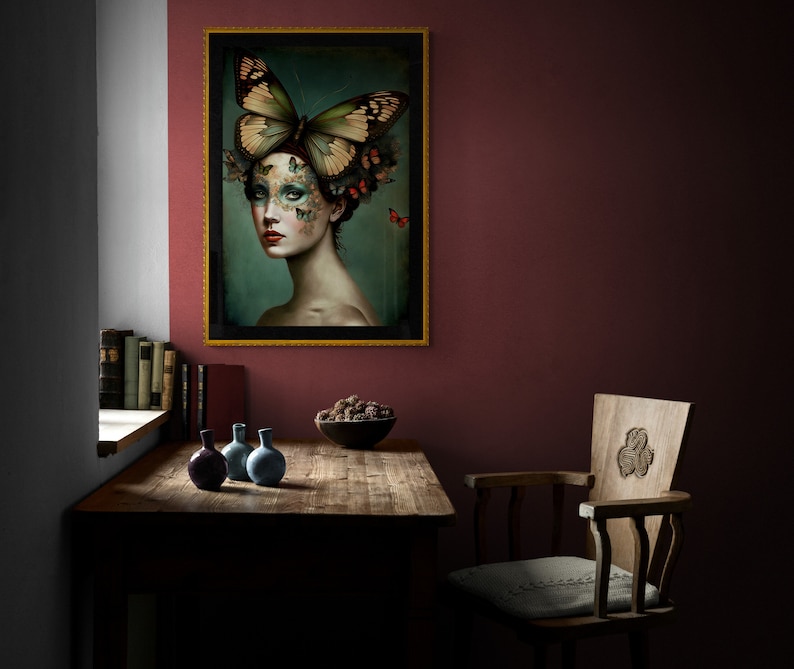 May include: A framed print of a woman with a butterfly on her head. The woman's face is covered in butterflies and she has a dark background. The frame is gold and the print is on a wall in a room with a wooden table and chairs.