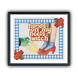 May include: A cross-stitch pattern featuring a green hand reaching for a pair of red shoes with the text "hands off my heels witch" in yellow and orange letters. The background is a blue and white checkered pattern.