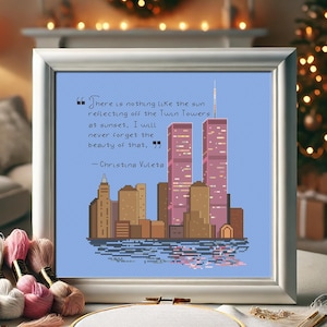 Könnte beinhalten: Ein gerahmtes Kreuzstich-Design mit einer Stadtlandschaft, die die Twin Towers zeigt, und einem Zitat: "Es gibt nichts Schöneres als die Sonne, die sich in den Twin Towers bei Sonnenuntergang spiegelt. Ich werde die Schönheit davon nie vergessen." - Christina Vuleta