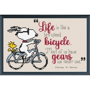 May include: A white cartoon dog riding a blue bicycle with a yellow bird on the back seat. The quote "Life is like a ten speed bicycle. Most of us have gears we never use." by Charles M. Schulz is written in red.