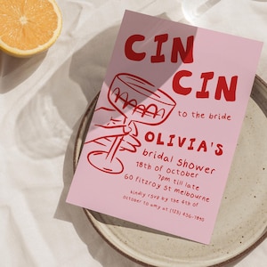 May include: A pink bridal shower invitation with red text and a cocktail glass illustration. The invitation includes the text "CIN CIN to the bride" and details for Olivia's bridal shower, along with an RSVP contact.