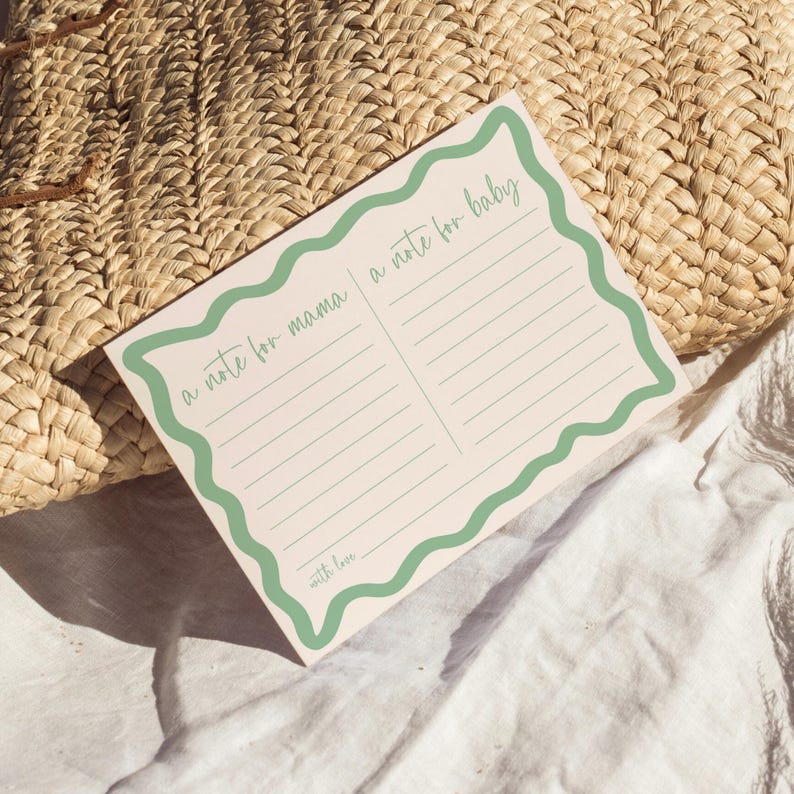 A note card with a green border and blank lines, placed on a woven straw mat.