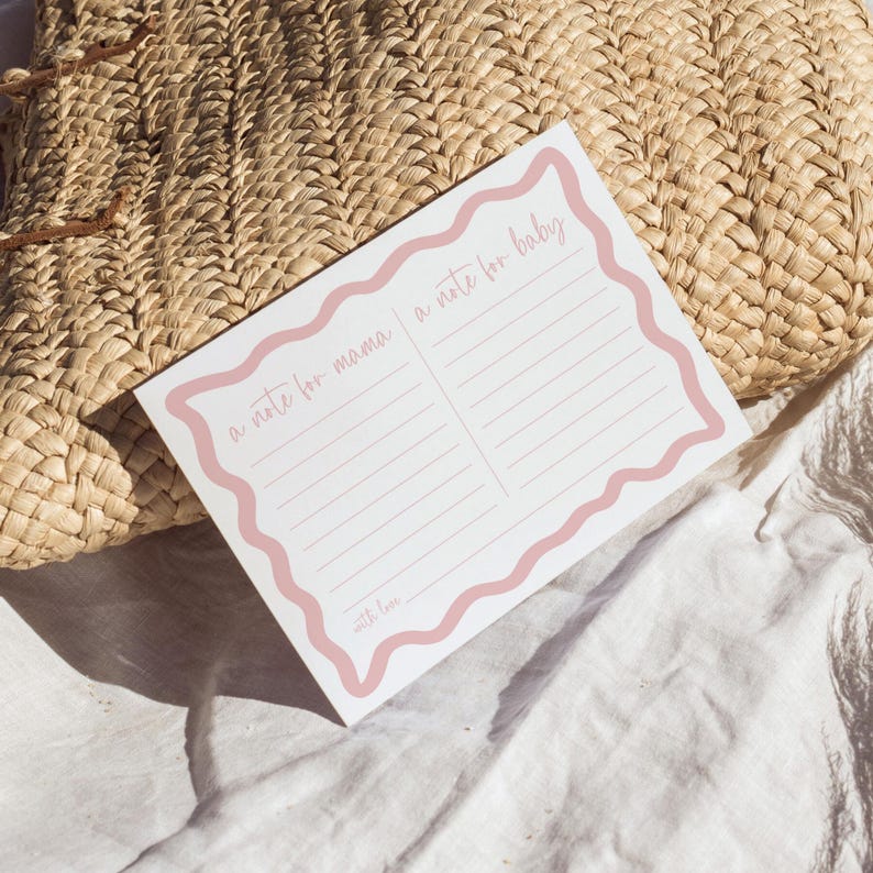 A note card with a pink border and blank lines is placed on a woven straw mat.