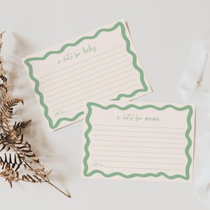 two blank green-bordered note cards with blank lines, placed on a white background.